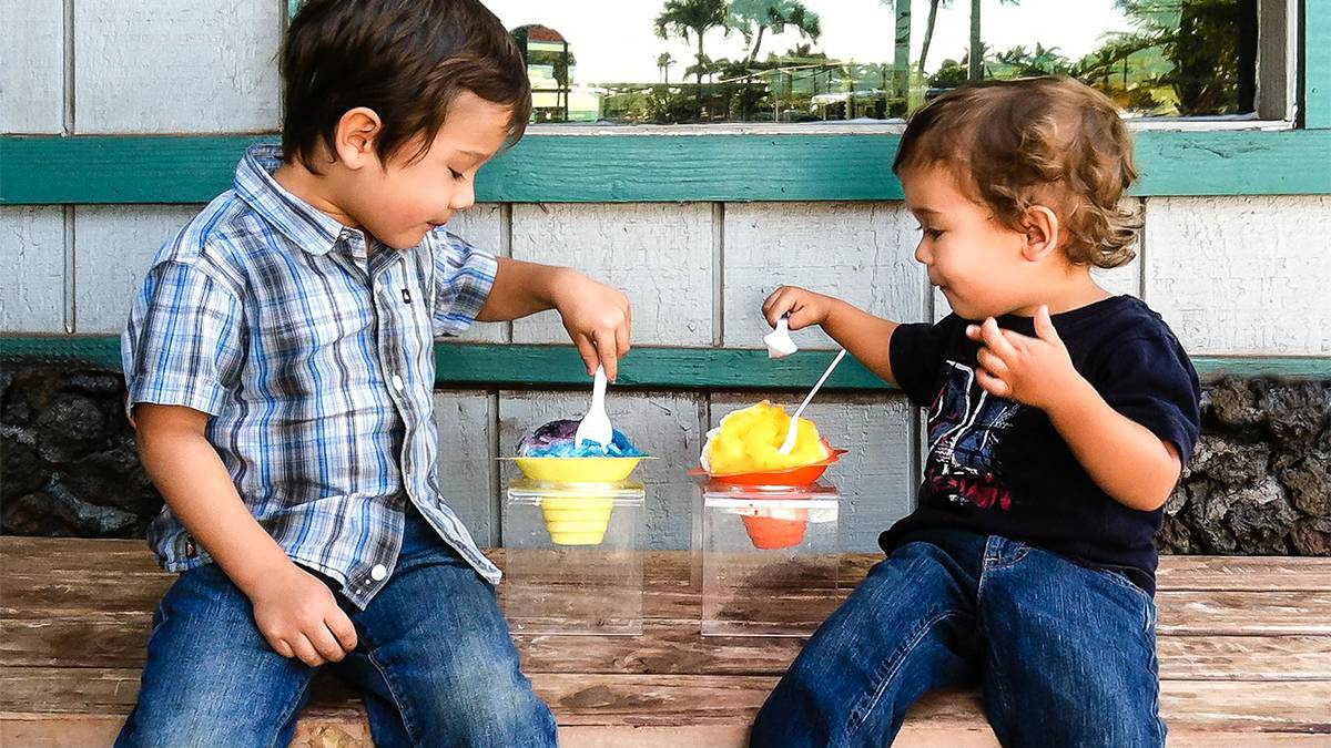 Kids sitting and eating bowls of shaved hawaiian ice from Ululani Hawaiian Shave Ice in Maui Hawaii